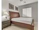 Cozy bedroom featuring a wood frame bed, side table with lamp, and window with blinds at 6938 Silk Oak Ct, Las Vegas, NV 89148