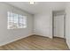 Bright bedroom with wood-look flooring, a window and a closet with sliding doors at 6938 Silk Oak Ct, Las Vegas, NV 89148