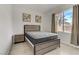 Modern bedroom with a platform bed, side table, and a bright window with curtains at 6938 Silk Oak Ct, Las Vegas, NV 89148