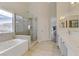 Bright main bathroom with double sinks, a soaking tub, and a glass-enclosed shower at 6938 Silk Oak Ct, Las Vegas, NV 89148