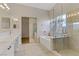 Main bathroom featuring double sinks, a soaking tub, and a glass-enclosed shower at 6938 Silk Oak Ct, Las Vegas, NV 89148