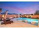 Backyard pool with built-in spa, water feature, and lounge seating at dusk at 7165 N Grand Canyon Dr, Las Vegas, NV 89149