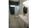 Modern bathroom boasts dark blue tile, a patterned shower curtain, and double sink vanity at 7444 Grassy Field Ct, Las Vegas, NV 89131