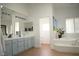 This bathroom features double sinks, light blue cabinetry, and a stand alone tub at 7444 Grassy Field Ct, Las Vegas, NV 89131