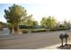 Charming neighborhood street view with mature trees, well-maintained landscaping, and community playground in the distance at 7444 Grassy Field Ct, Las Vegas, NV 89131