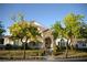 Inviting two-story home featuring a stone facade, covered entry, and lush green landscaping at 7444 Grassy Field Ct, Las Vegas, NV 89131