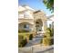 Inviting front entrance with stone archway, manicured bushes, and tiled roof, creating a welcoming curb appeal at 7444 Grassy Field Ct, Las Vegas, NV 89131