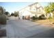 Exterior of home featuring a large driveway, three-car garage, and tidy landscaping at 7444 Grassy Field Ct, Las Vegas, NV 89131