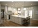 Bright kitchen featuring white cabinetry, a large island with seating, and modern appliances at 7444 Grassy Field Ct, Las Vegas, NV 89131