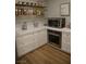 Bright kitchen features white cabinets, stainless steel appliances, and wood-look floors at 7444 Grassy Field Ct, Las Vegas, NV 89131