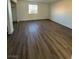 Spacious bedroom with wood-look flooring, neutral paint, and a large window at 800 N Torrey Pines Dr, Las Vegas, NV 89107