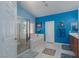 Bathroom with walk-in shower and separate tub with oak cabinetry, white tile and bright blue walls at 8213 Cabin Springs Ave, Las Vegas, NV 89131