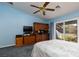 Bedroom area features oak furnishings, sliding glass doors, blue walls and carpet, and a ceiling fan at 8213 Cabin Springs Ave, Las Vegas, NV 89131