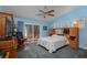 Bright bedroom with blue walls, a ceiling fan, and a sliding glass door leading to an outdoor space at 8213 Cabin Springs Ave, Las Vegas, NV 89131