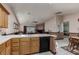 Kitchen area features an oak cabinets, a ceramic tile counter, tile floor and a view to the living spaces at 8213 Cabin Springs Ave, Las Vegas, NV 89131