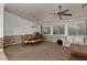 Open-concept living room with ceiling fan and large windows for natural light offers comfortable seating arrangements at 8213 Cabin Springs Ave, Las Vegas, NV 89131