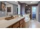 Relaxing bathroom featuring dual sinks, tub, and vanity with warm wood cabinets at 8558 Rumsfield Ct, Las Vegas, NV 89131