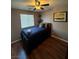 Cozy bedroom featuring a ceiling fan, a large window, warm wall colors and hardwood floors at 8558 Rumsfield Ct, Las Vegas, NV 89131