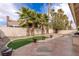 Private backyard featuring tiled patio, palm trees, artificial turf, and stucco walls at 8736 Vista Ladera Ct, Las Vegas, NV 89147