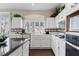 Bright kitchen with white cabinets, tile countertops, stainless steel appliances and garden window at 8736 Vista Ladera Ct, Las Vegas, NV 89147