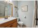 Cozy bathroom with a oak vanity, mirror and toilet at 8805 Pavia Dr, Las Vegas, NV 89117