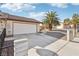 Exterior view of a home's side featuring a two-car garage, driveway, walkway and desert landscaping at 8805 Pavia Dr, Las Vegas, NV 89117