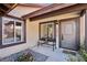 Covered front porch featuring desert landscaping, bench seating, exterior lighting and front door at 8805 Pavia Dr, Las Vegas, NV 89117