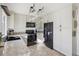 Bright kitchen featuring white cabinets, a black refrigerator, and a modern countertop at 8805 Pavia Dr, Las Vegas, NV 89117