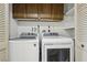 Bright laundry room featuring a washer and dryer next to shelving space and shutter doors at 8805 Pavia Dr, Las Vegas, NV 89117