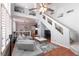 Bright open-concept living room featuring high ceilings, large windows, and staircase at 8872 Hampton Green Ave, Las Vegas, NV 89129