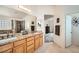 Bright bathroom with double sinks, granite countertops, and walk-in shower reflected in the mirror at 9071 Ravenhurst St, Las Vegas, NV 89123