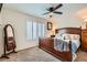 Comfortable bedroom featuring a wood-frame bed, ceiling fan, soft carpet, and shuttered window at 9071 Ravenhurst St, Las Vegas, NV 89123