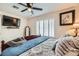 Bedroom with a ceiling fan, shuttered window, and mounted television at 9071 Ravenhurst St, Las Vegas, NV 89123