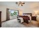 Spacious main bedroom featuring a ceiling fan, large window, and plush carpeting at 9071 Ravenhurst St, Las Vegas, NV 89123