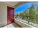 Charming balcony with a red door overlooking green trees and blue sky at 950 Seven Hills Dr # 722, Henderson, NV 89052