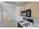 A well lit kitchen with gas range, black microwave, and wood cabinets at 950 Seven Hills Dr # 722, Henderson, NV 89052