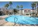 Resort-style pool with palm trees, lounge chairs, and clear blue water at 950 Seven Hills Dr # 722, Henderson, NV 89052