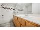 Bright bathroom featuring double sinks, a large mirror, and a tiled tub-shower with a curtain at 9725 La Cienega St, Las Vegas, NV 89183