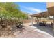 Paver patio and desert landscaping surround a covered patio, perfect for relaxing or entertaining at 9792 Valmeyer Ave, Las Vegas, NV 89148