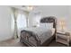 Bedroom featuring carpeted floor, a large window, stylish decor and furnishings, and neutral colored walls at 9792 Valmeyer Ave, Las Vegas, NV 89148