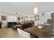 Open-concept living room and dining area featuring tile floors and contemporary lighting at 9792 Valmeyer Ave, Las Vegas, NV 89148