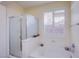 Bright bathroom featuring a glass-enclosed shower and soaking tub beneath a window with white shutters at 11773 Golden Moments Ave, Las Vegas, NV 89138