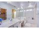 Bright bathroom with double sinks, a large mirror, and a separate bathtub area at 11773 Golden Moments Ave, Las Vegas, NV 89138