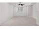 This bedroom features neutral carpeting, a modern ceiling fan, and a window with stylish blinds at 10052 Silver Comet Ct, Las Vegas, NV 89178