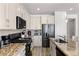 Modern kitchen with black stainless-steel appliances, granite countertops, and ample cabinet space at 10052 Silver Comet Ct, Las Vegas, NV 89178