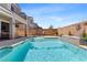 Sparkling blue pool with a waterfall feature and outdoor lounge area at 10052 Silver Comet Ct, Las Vegas, NV 89178