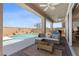 Inviting outdoor living space featuring a covered patio, a refreshing pool with waterfall feature, and comfortable seating at 10052 Silver Comet Ct, Las Vegas, NV 89178