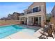 Inviting backyard featuring a private pool, covered patio, outdoor seating, and desert landscaping at 10052 Silver Comet Ct, Las Vegas, NV 89178
