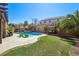 Beautiful backyard featuring a pool with a spa, a lush lawn, and a swing for relaxing at 1033 Via Dell Bacio Dr, Henderson, NV 89052