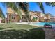 Inviting backyard featuring a sparkling pool, patio with pergola and lush greenery at 1033 Via Dell Bacio Dr, Henderson, NV 89052